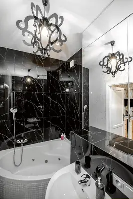 a bathroom with a sink and a bath tub and a chandelier at Słowackiego Apartments in Kraków