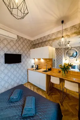 a kitchen with a bed and a desk in a room at Słowackiego Apartments in Kraków