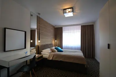 a hotel room with a bed and a desk and a window at Willa Wiesia Rabka Zdrój in Rabka