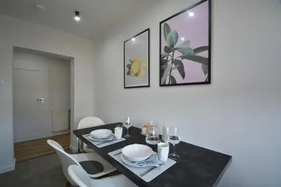 a dining room with a black table and white chairs at Willa Wiesia Rabka Zdrój in Rabka