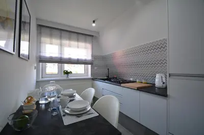 a kitchen with a table with chairs and a counter top at Willa Wiesia Rabka Zdrój in Rabka