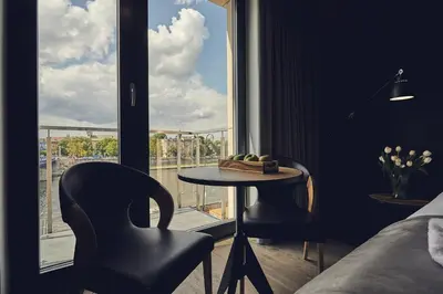a room with a table and two chairs and a window at The Bridge Suites Hotel in Kraków