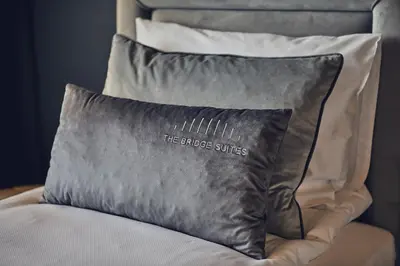 a pillow with the strokes cutouts on it sitting on a chair at The Bridge Suites Hotel in Kraków