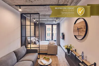 a living room with a couch and a bed at The Bridge Suites Hotel in Kraków