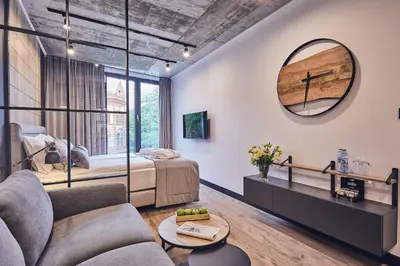 a bedroom with a bed and a large mirror at The Bridge Suites Hotel in Kraków