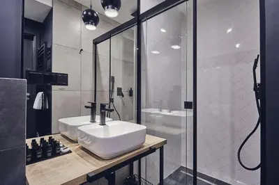 a bathroom with a white sink and a shower at The Bridge Suites Hotel in Kraków