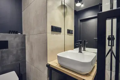 a bathroom with a white sink and a mirror at The Bridge Suites Hotel in Kraków