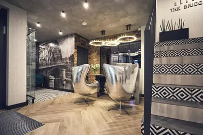 a salon with two silver chairs and a table at The Bridge Suites Hotel in Kraków