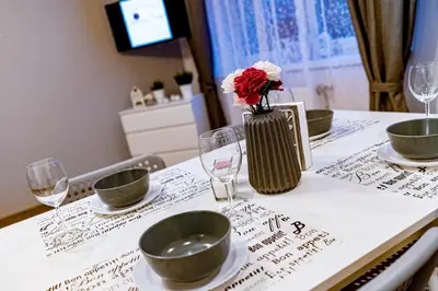 a table with bowls and a vase with flowers on it at Kopalnia Snów in Wieliczka