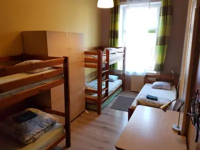 a small room with bunk beds and a table at Dream Hostel & Apartments in Kraków