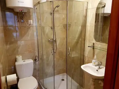 a bathroom with a shower and a toilet and a sink at Dream Hostel & Apartments in Kraków