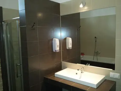 a bathroom with a sink and a mirror at Dream Hostel & Apartments in Kraków