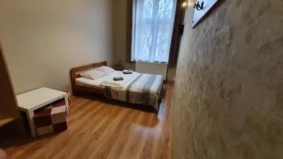 a small bedroom with a bed and a window at Dream Hostel & Apartments in Kraków