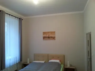 a bedroom with a bed and a picture on the wall at Dream Hostel & Apartments in Kraków