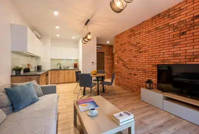 a living room with a couch and a brick wall at Marvels Place with parking and AC in Kraków