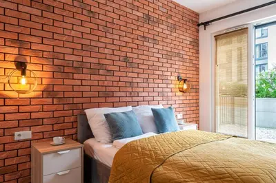 a bedroom with a brick wall and a bed at Marvels Place with parking and AC in Kraków