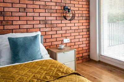 a bedroom with a brick wall and a bed at Marvels Place with parking and AC in Kraków