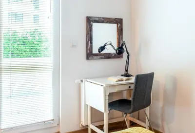 a desk with a chair and a mirror at Marvels Place with parking and AC in Kraków