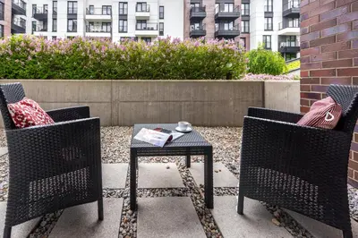 a patio with two chairs and a table with a cup on it at Marvels Place with parking and AC in Kraków