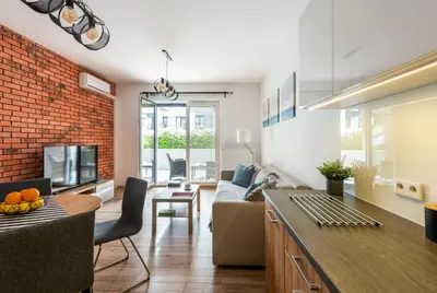 a living room with a couch and a table at Marvels Place with parking and AC in Kraków