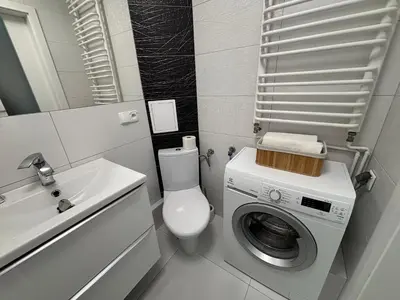 a bathroom with a washing machine and a sink at Ekskluzywny Apartament Joanna w centrum Bochni in Bochnia