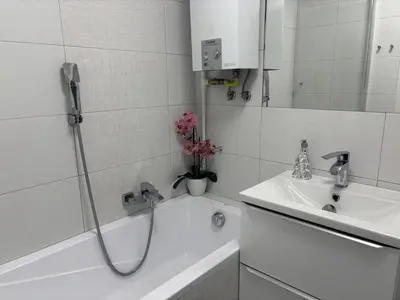 a white bathroom with a shower and a sink at Ekskluzywny Apartament Joanna w centrum Bochni in Bochnia