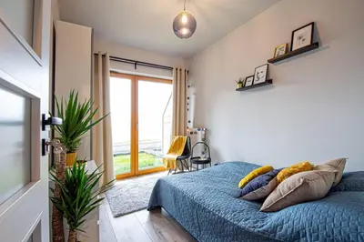 a bedroom with a blue bed and a large window at Apartament with Garden BEZPŁATNY PARKING !!! in Kraków