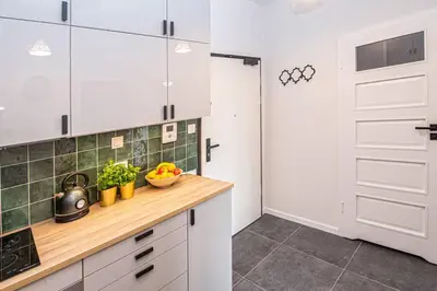 a white living room with a table and chairs at Apartament with Garden BEZPŁATNY PARKING !!! in Kraków