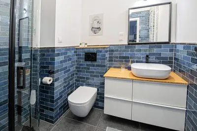 a kitchen with white cabinets and a wooden counter top at Apartament with Garden BEZPŁATNY PARKING !!! in Kraków