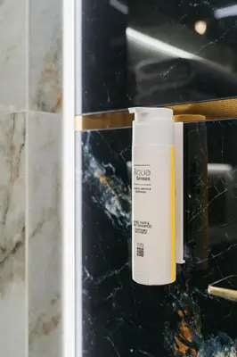 a bottle of sunscreen sitting on a counter in a bathroom at Native Apartments Lubelska 14 in Kraków
