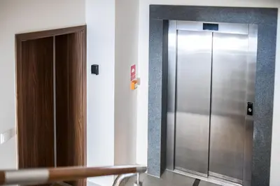 a metal elevator in a room with a door at Native Apartments Lubelska 14 in Kraków
