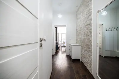 a hallway with a white door and a room at Native Apartments Lubelska 14 in Kraków