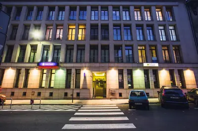 a large building with cars parked in front of it at Wielopole17 Miro Apartment with AC in Kraków