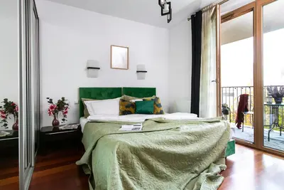 a bedroom with a large bed with a green blanket at Otium Old Town Angel Plaza in Kraków