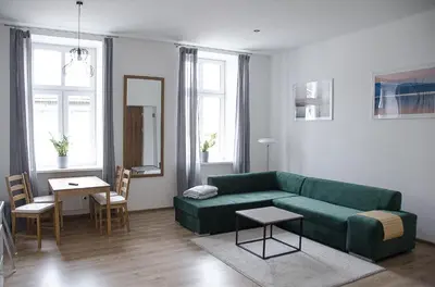 a living room with a green couch and a table at Apartament Mickiewicza in Wadowice