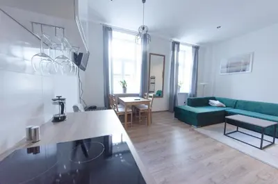 a living room with a green couch and a table at Apartament Mickiewicza in Wadowice