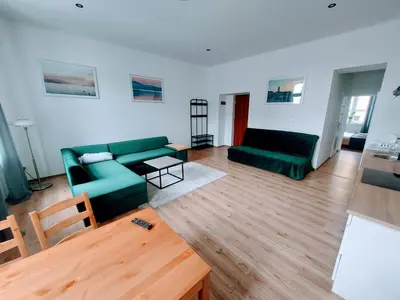a living room with two green couches and a table at Apartament Mickiewicza in Wadowice