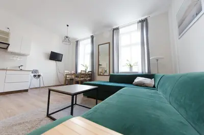 a living room with a green couch and a table at Apartament Mickiewicza in Wadowice