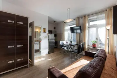 a living room with a couch and a dining room at Komfortowy apartament - obok Rynku in Kraków