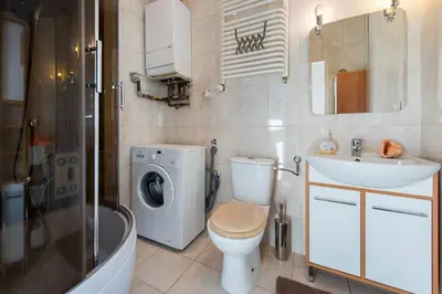 a bathroom with a toilet sink and a washing machine at Komfortowy apartament - obok Rynku in Kraków