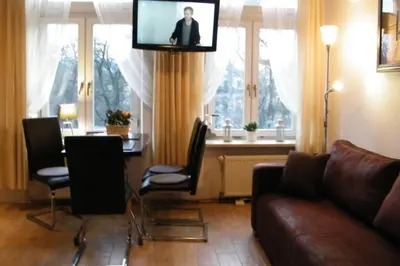 a living room with a couch and a flat screen tv at Komfortowy apartament - obok Rynku in Kraków