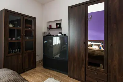 a bedroom with a tv and a wooden cabinet at Komfortowy apartament - obok Rynku in Kraków