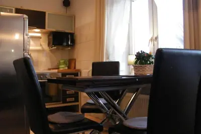 a kitchen with a table with chairs and a refrigerator at Komfortowy apartament - obok Rynku in Kraków