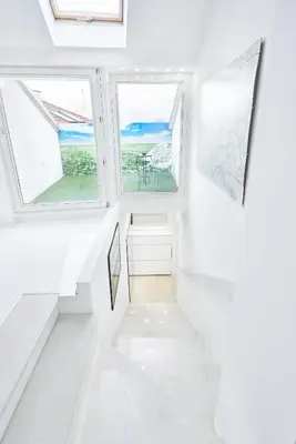 a white hallway with two windows and a table at UNIQUE DESIGN Loft in middle of CENTRE of OLD TOWN with Netflix in Kraków