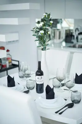 a white table with a bottle of wine and glasses at UNIQUE DESIGN Loft in middle of CENTRE of OLD TOWN with Netflix in Kraków