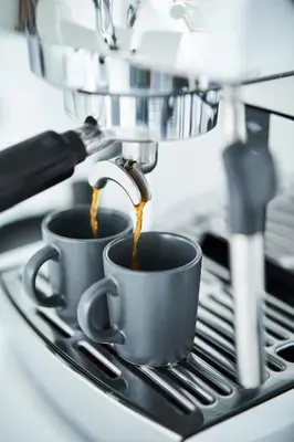two cups of coffee being brewed in a coffee machine at UNIQUE DESIGN Loft in middle of CENTRE of OLD TOWN with Netflix in Kraków