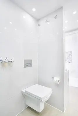 a white bathroom with a toilet and a shower at UNIQUE DESIGN Loft in middle of CENTRE of OLD TOWN with Netflix in Kraków