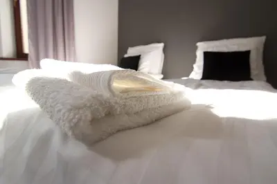a white towel sitting on top of a bed at Cracow bb in Kraków