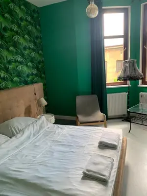a bedroom with a bed and a green wall at Cracow bb in Kraków