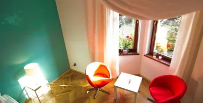 a room with two red chairs and a window at Cracow bb in Kraków